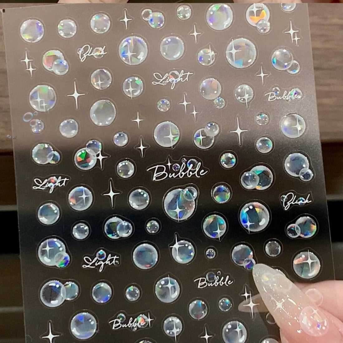 Five translucent iridescent bubble light sticker sheets with white sparkle accents
