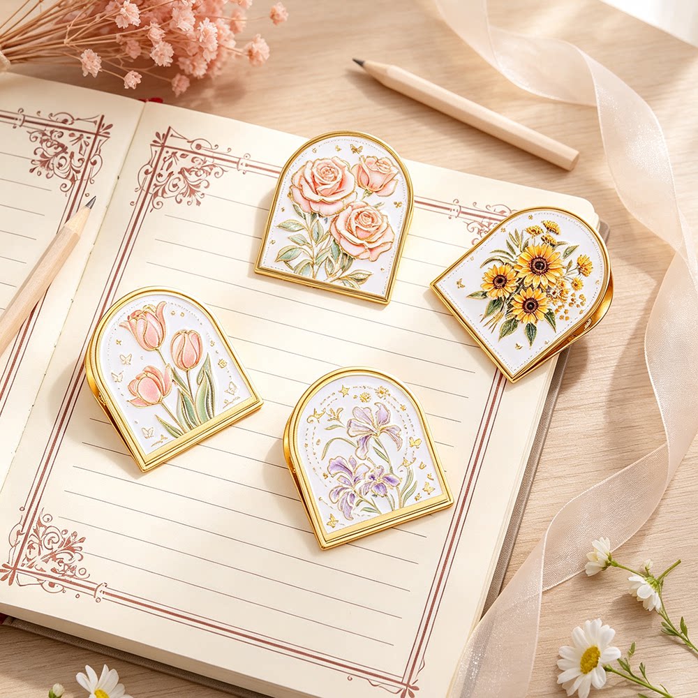 Gold-trim enamel journal clips clipped onto a decorative notebook page