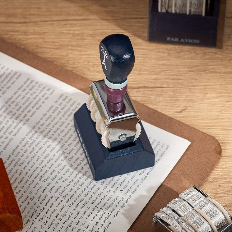 Vintage date roller stamp with wood-style handle, retro postal lettering, metal date wheels, and desk display base