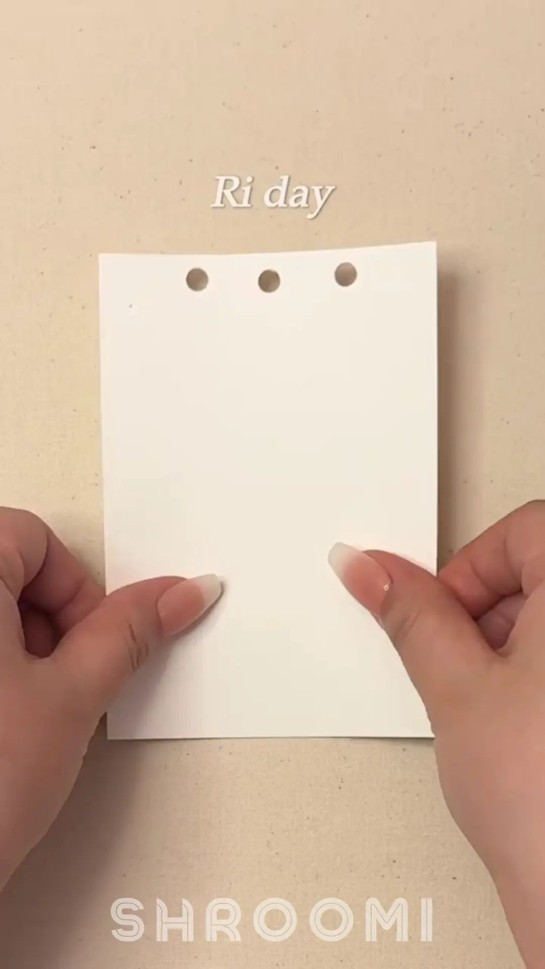 White card with 3 holes held by hands on a beige background