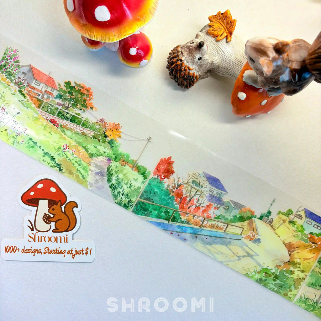 Charming watercolor PET tape featuring a countryside landscape with cherry blossoms, cottages, bridges, and winding roads.