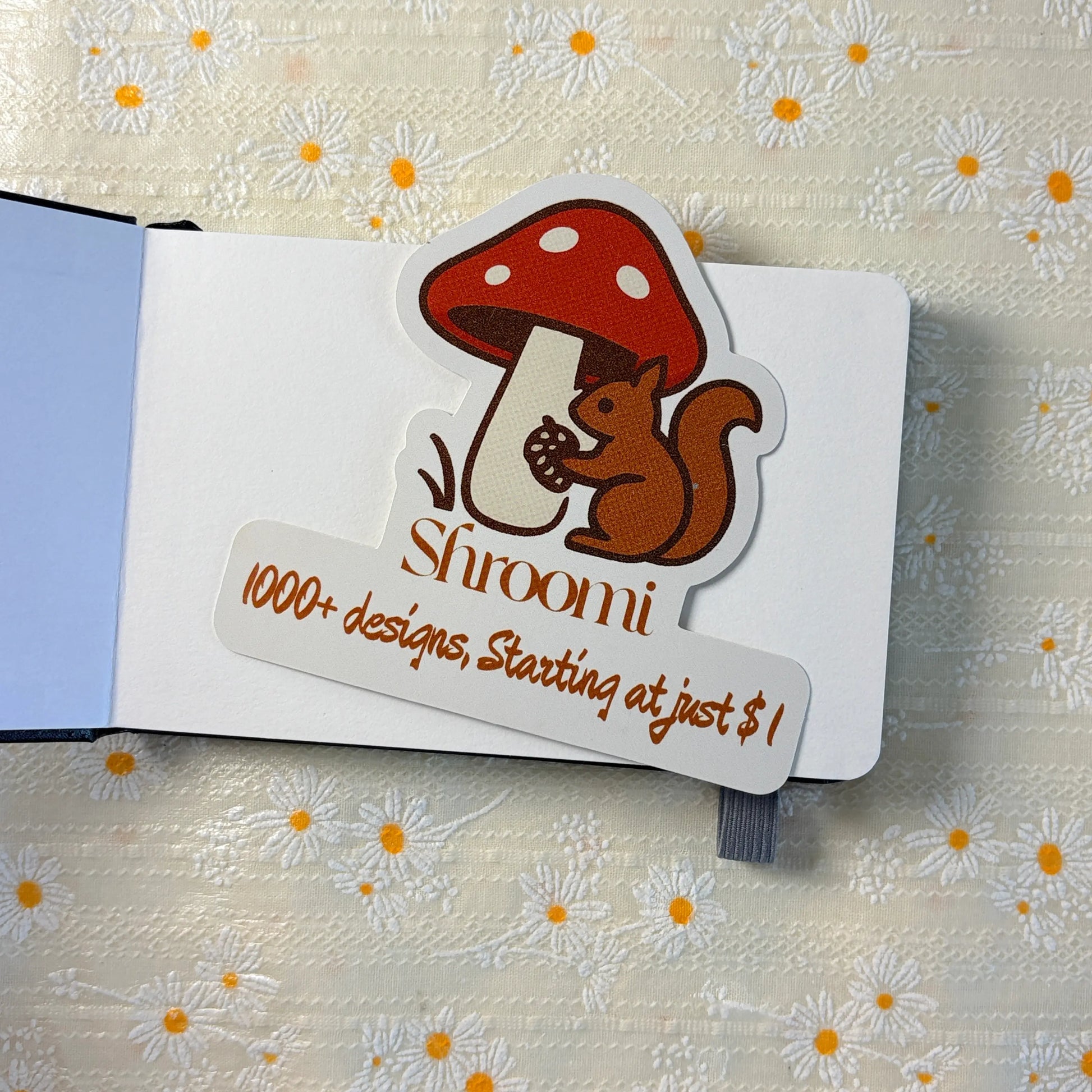 Close-up of black hardcover journal notebook with elastic band closure and Shroomi sticker