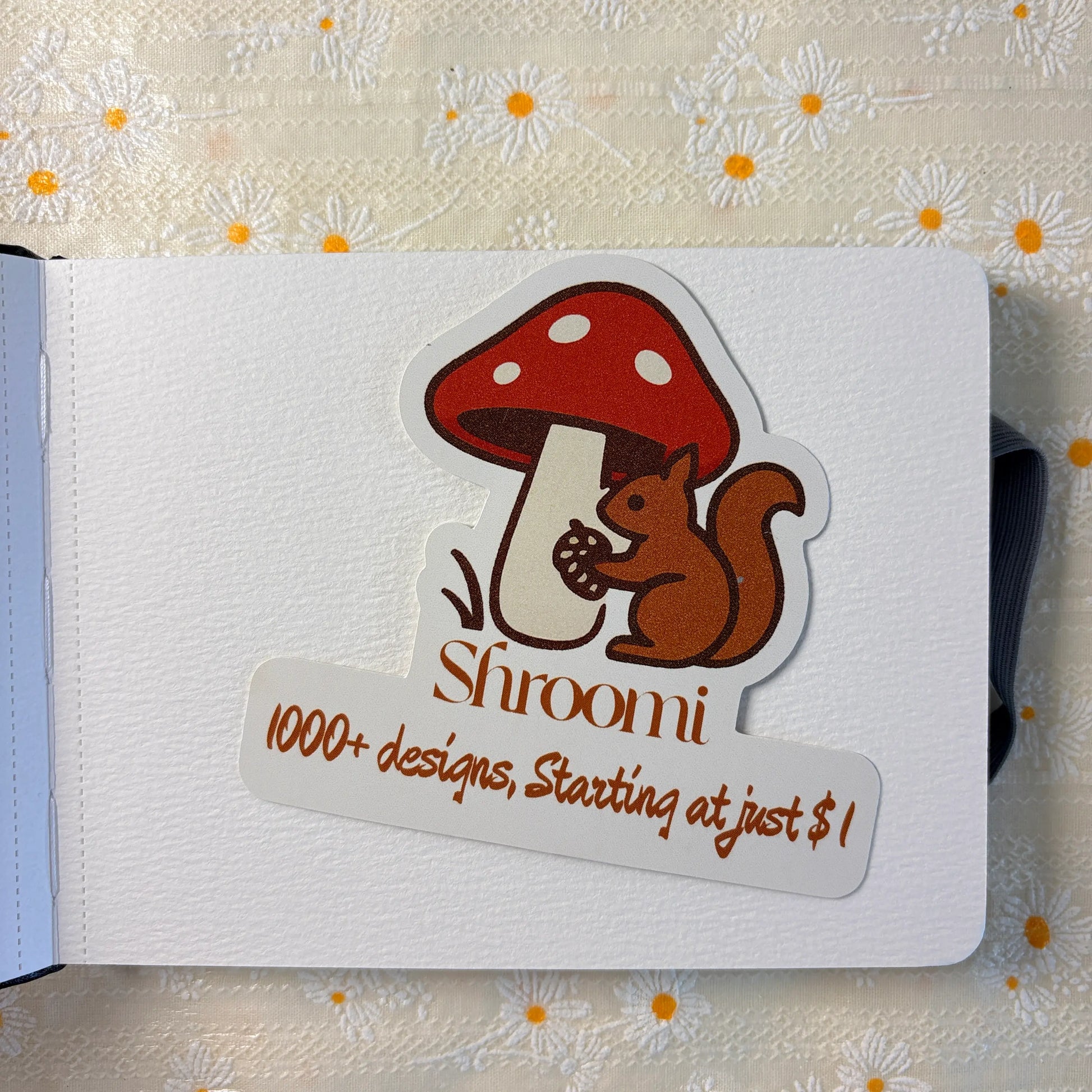 Black hardcover journal notebook with Shroomi branded mushroom squirrel sticker card