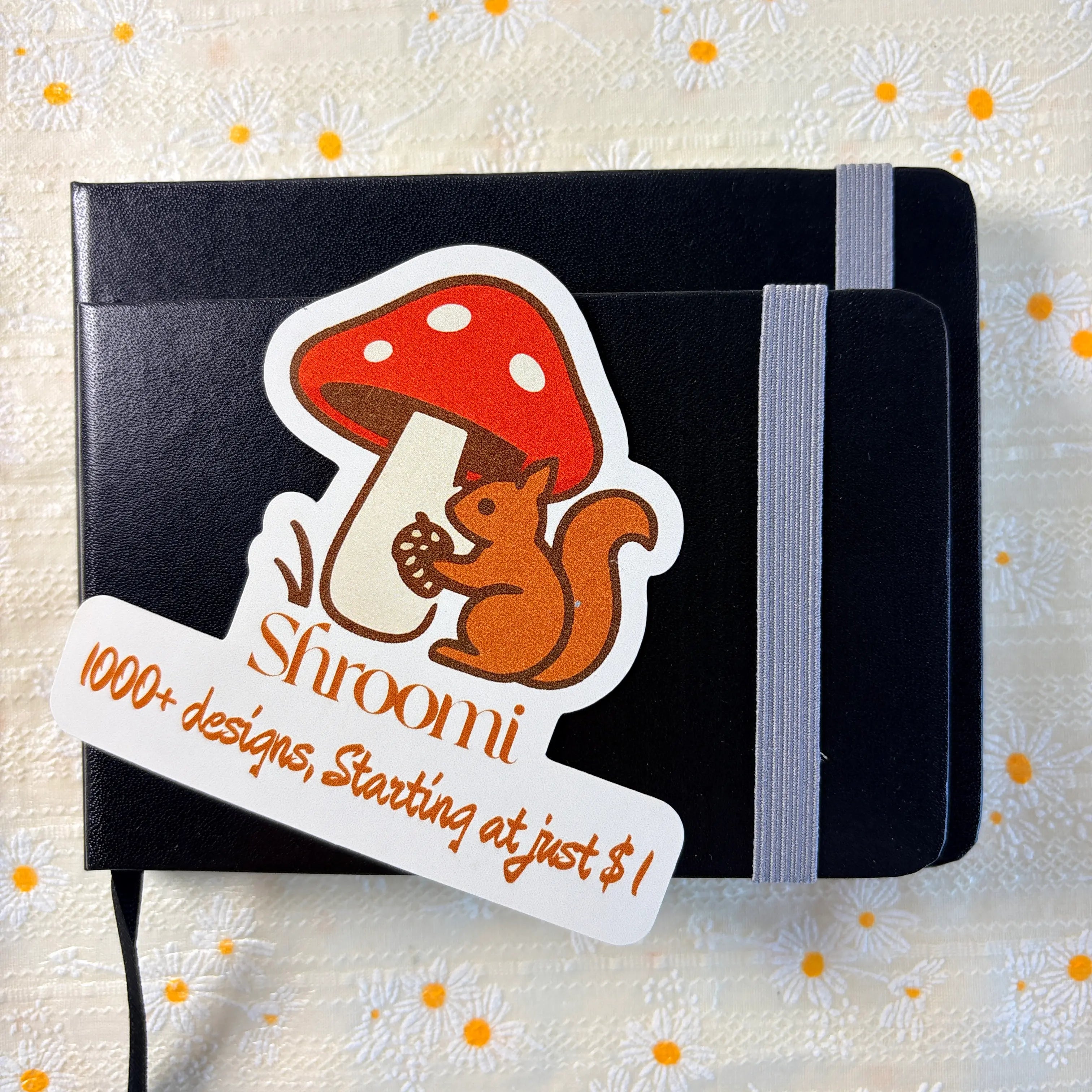 Black hardcover techo journal notebook standing upright with elastic band closure and Shroomi sticker card