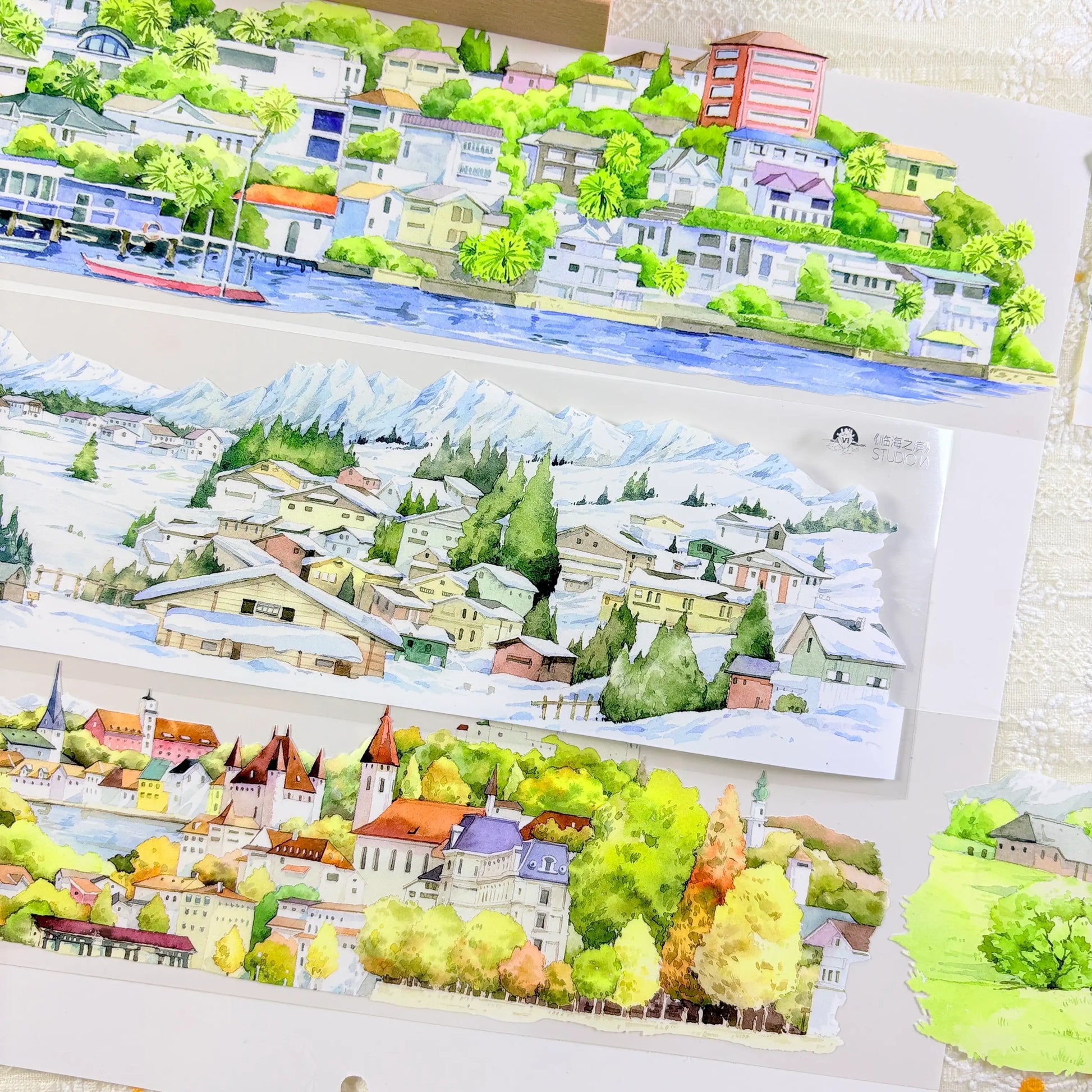 Four seasons panoramic PET tape showing coastal harbor town, snow alpine village, and European autumn cityscape