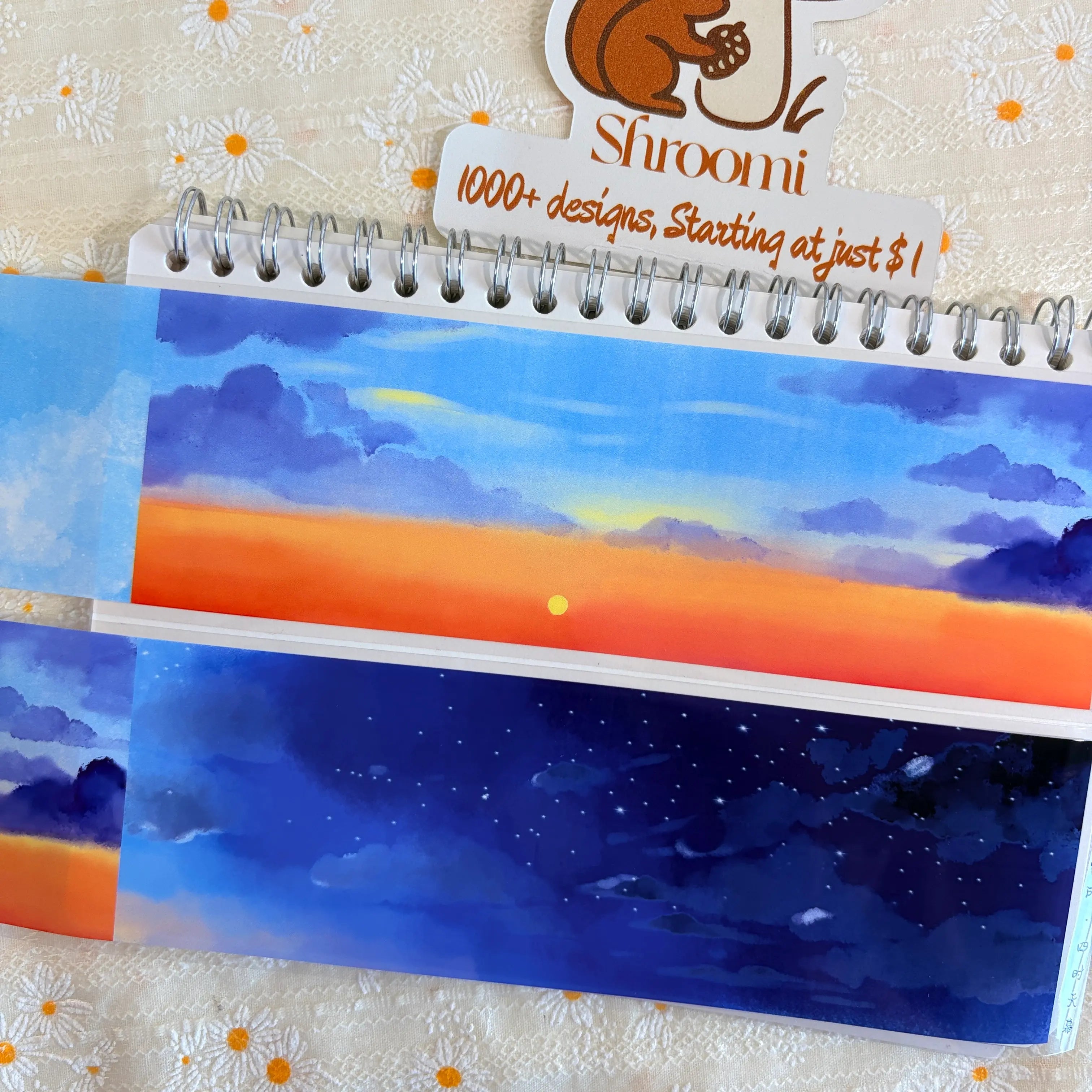 Shroomi Four Seasons Sky Background PET tape on journal — two strips: dramatic orange-red sunset sky with deep blue-purple storm clouds above (top), and deep indigo starry night sky with white star dots (bottom)