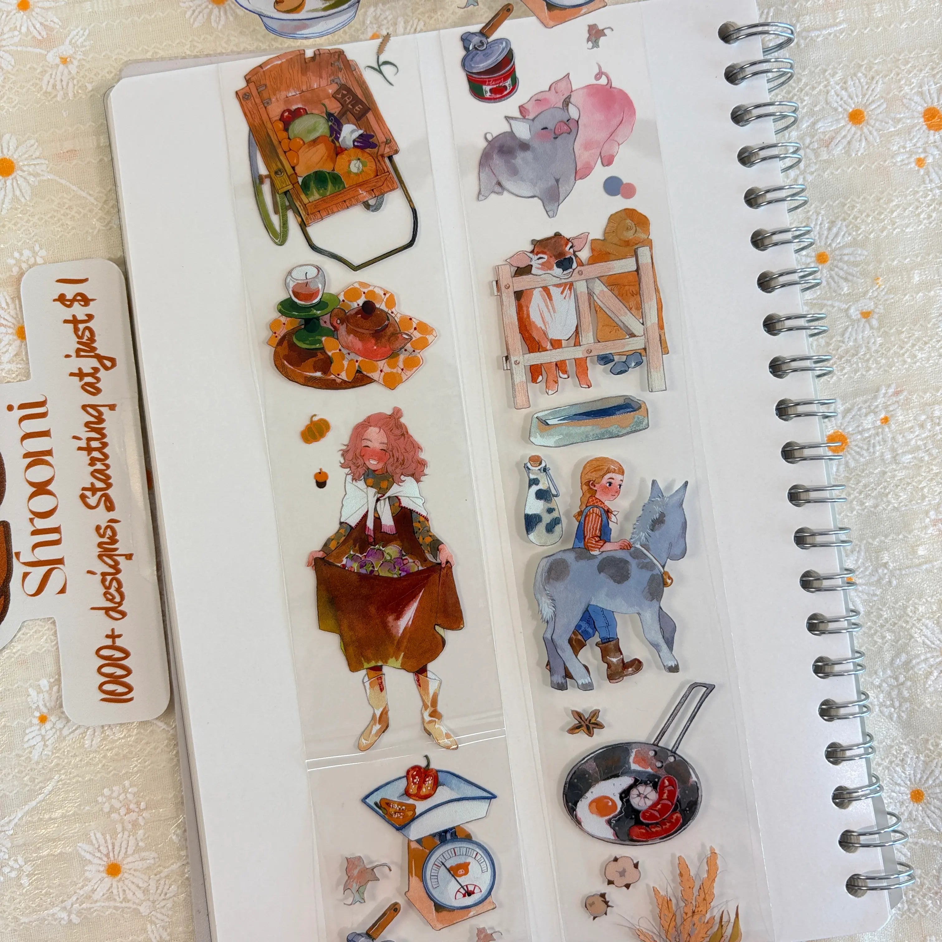 Shroomi PET tape on journal showing farm life: girl with pink hair carrying grapes in apron, wooden produce cart, cute pig, deer at wooden fence, girl leading a donkey, frying pan with eggs, weighing scale with peppers
