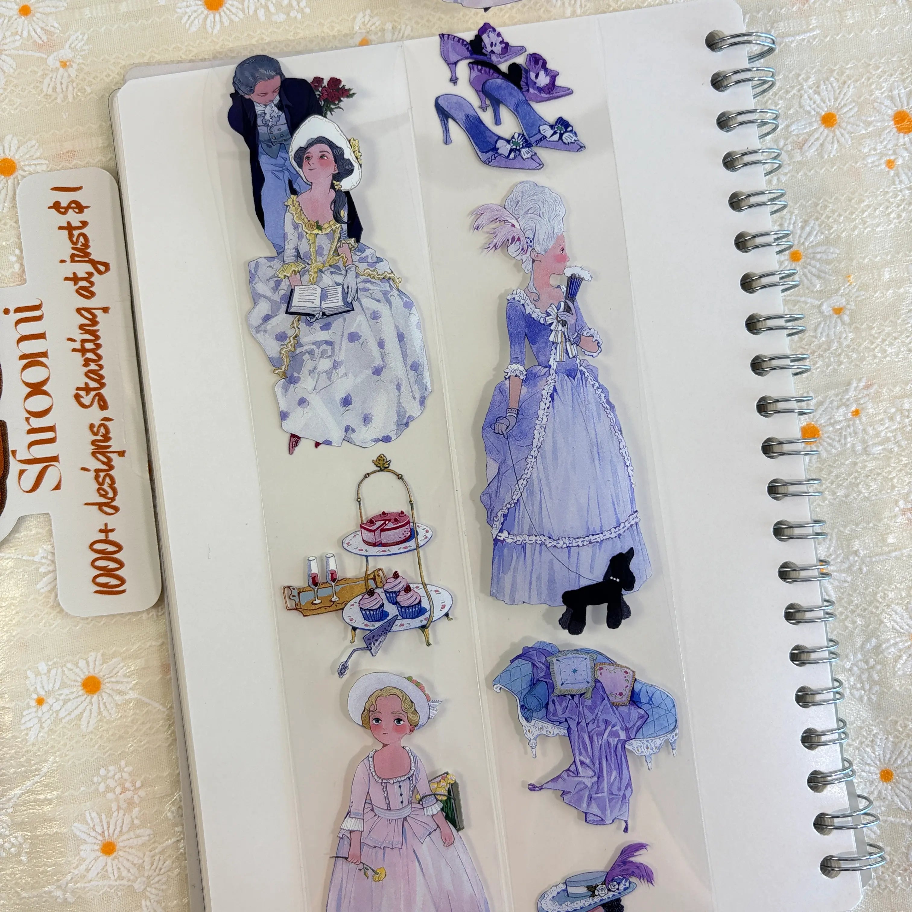 Shroomi PET tape on journal showing Rococo ballroom scenes: dancing couple, woman in lavender baroque gown with powdered wig walking black poodle, purple heels, tiered dessert stand with champagne and cupcakes