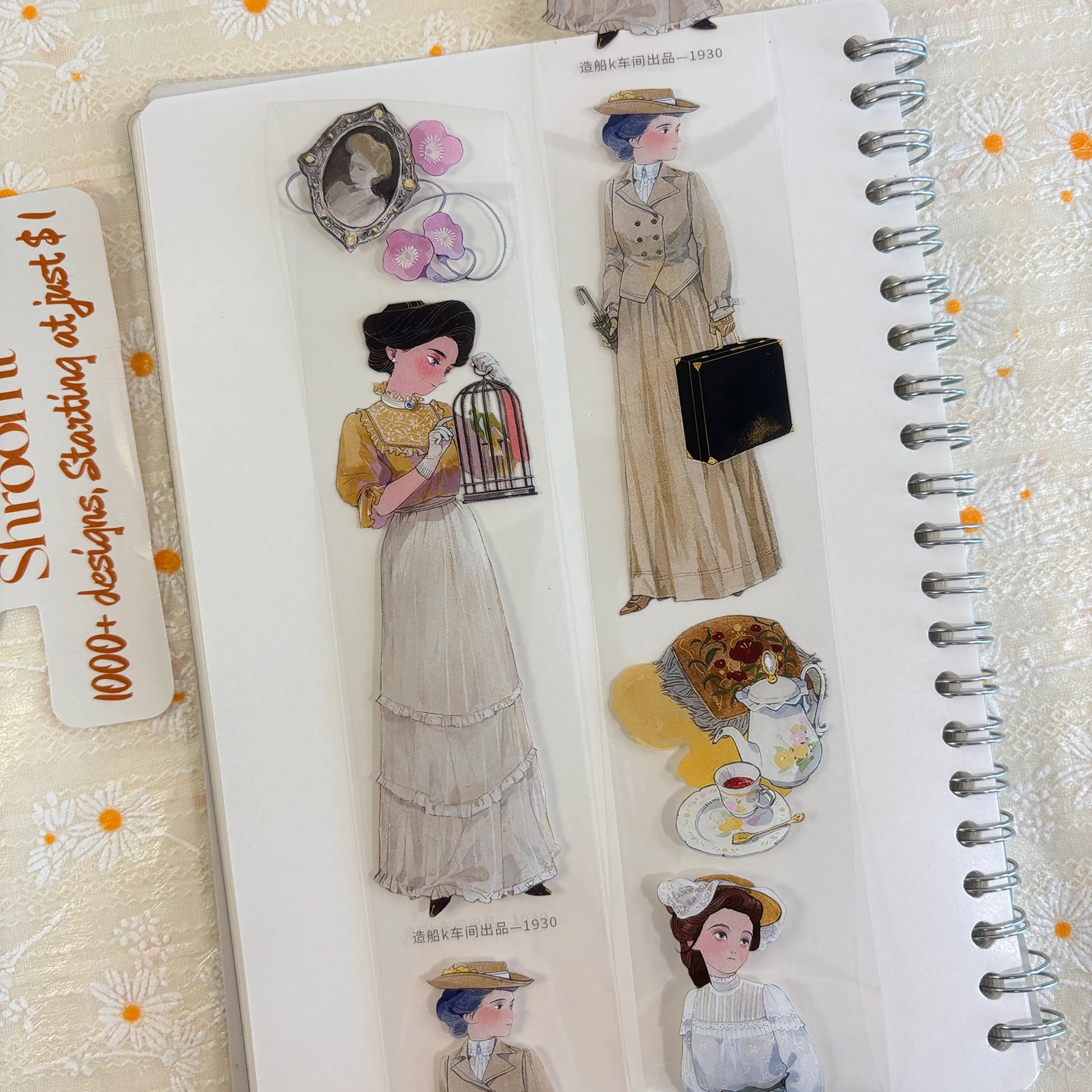 Shroomi PET tape on journal showing 1900s woman holding birdcage, 1930s woman in tailored beige suit with briefcase, ornate portrait frame with flowers, and floral tea set
