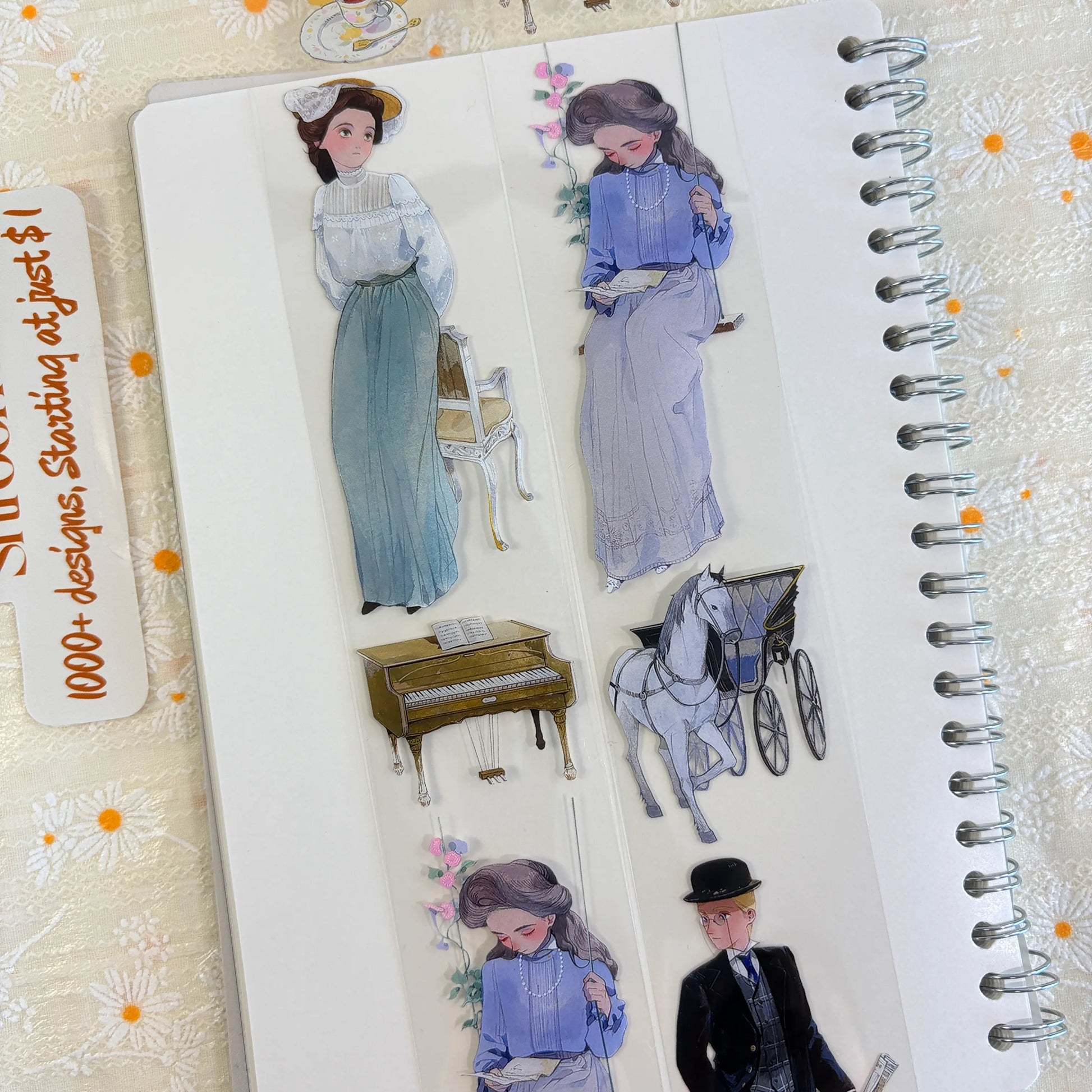 Shroomi PET tape on journal showing two Edwardian women in long teal and lavender dresses, upright piano, horse-drawn carriage, and gentleman in bowler hat