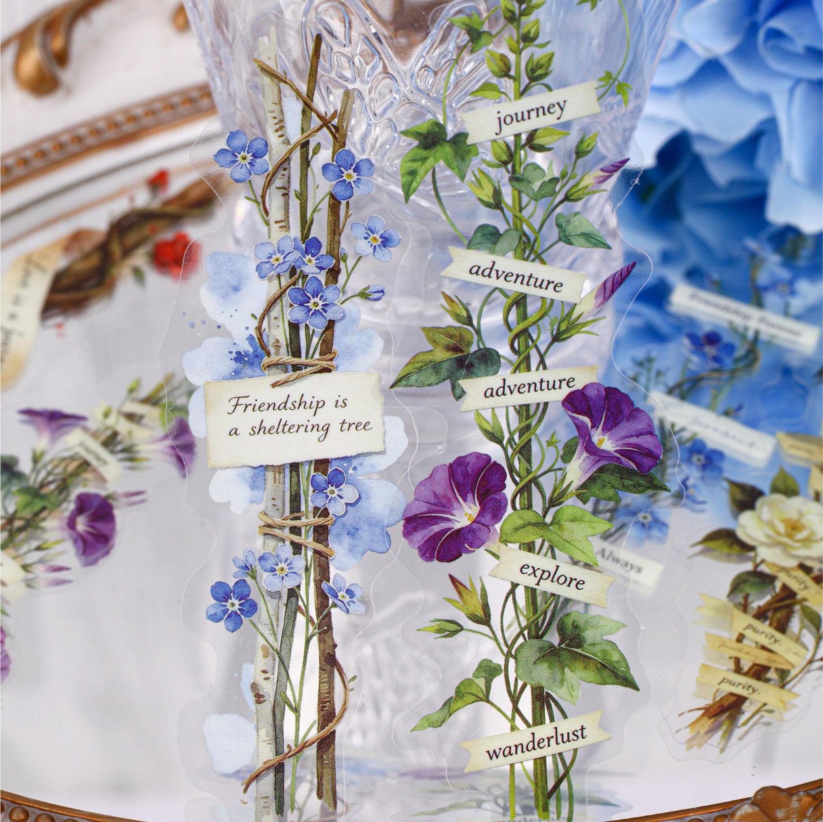 Pressed flower sticker details with blue flowers, purple petals, vines, and vintage labels