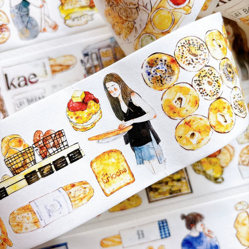Die-cut bakery girls and bread tape pieces layered on white paper