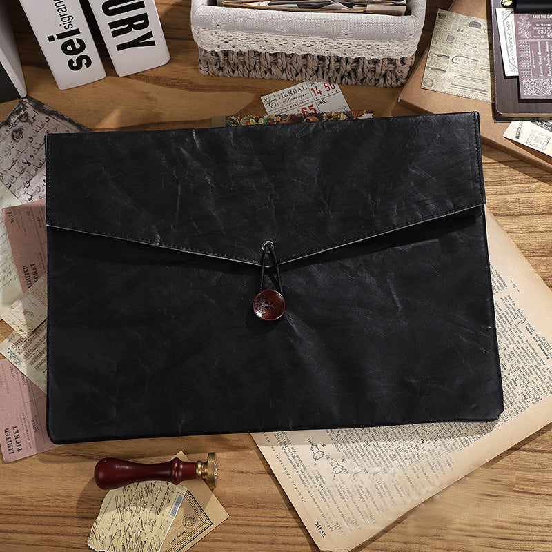 Black faux leather folder with a red button closure and rustic papers | Shroomi