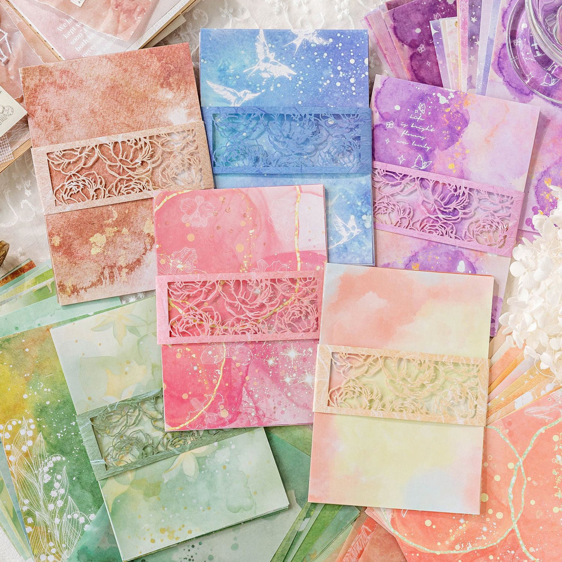 Watercolor wash scrapbooking paper with die-cut lace floral border detail
