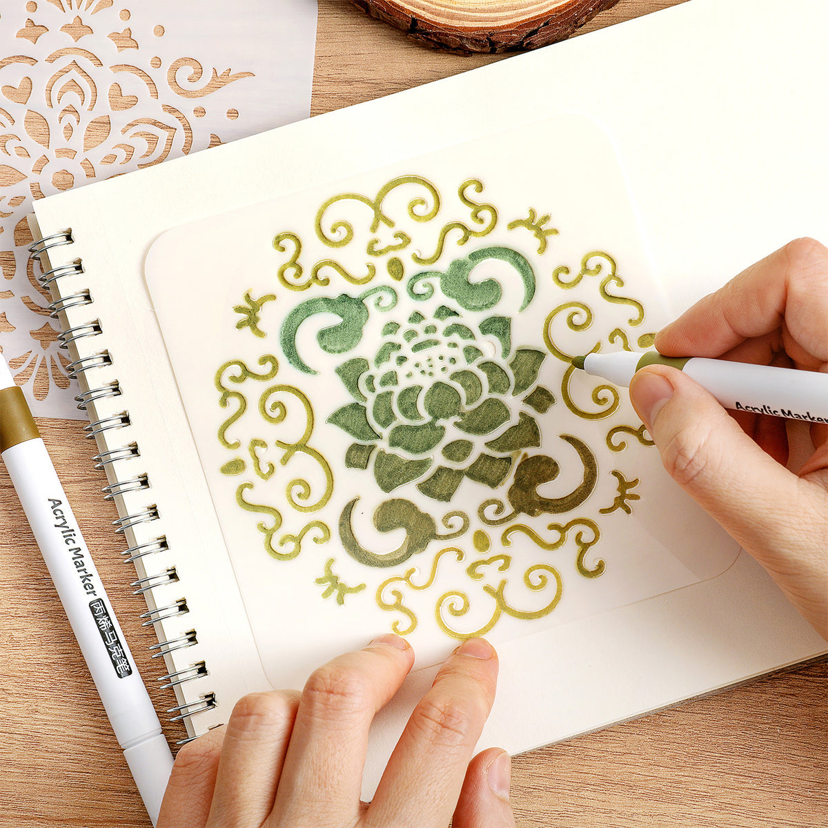 Hand coloring a mandala pattern through a stencil with markers in a sketchbook
