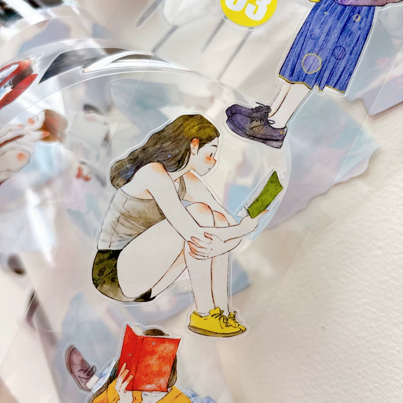 Die-cut girls reading books tape pieces layered on white paper