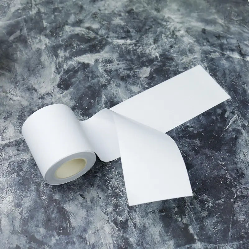 White base tape with release paper, showcasing a clean, smooth strip ideal for crafting and adhesive applications.