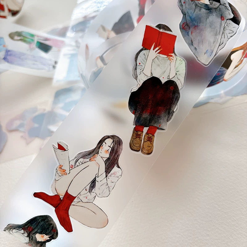 Die-cut girls reading books tape pieces layered on white paper