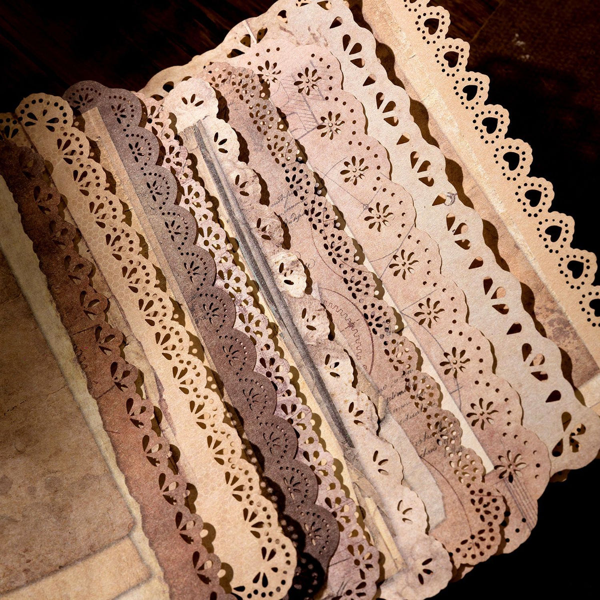 Vintage lace-edge scrapbooking paper design featuring antique lace borders and aged book-page texture