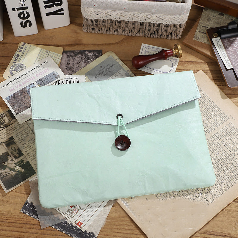 Flat lay of a light blue stationery pouch with a button closure, surrounded by vintage papers and journaling ephemera | Shroomi