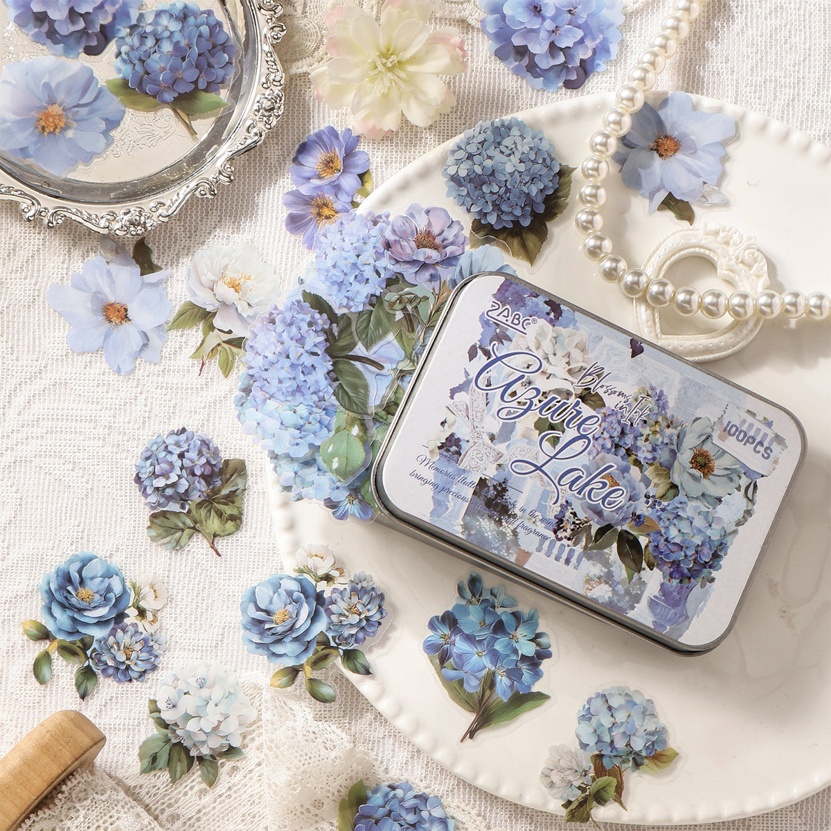 Blue hydrangea flower stickers around an illustrated sticker tin