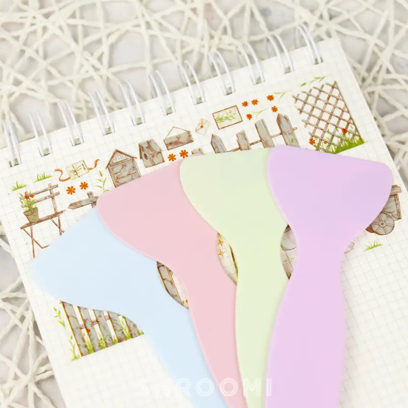 Handy plastic spatula designed for flattening stickers, ensuring a smooth, edge-free application on any surface.