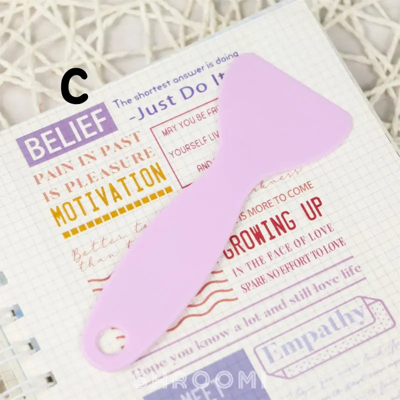 Handy plastic spatula designed to flatten stickers, ensuring a smooth, edge-free application on any surface.