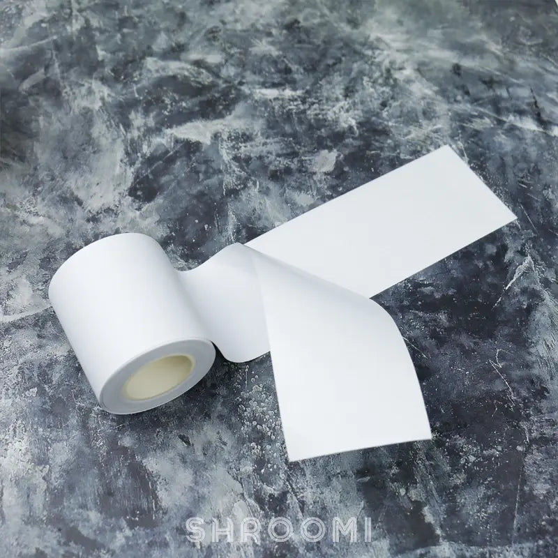 White base tape with release paper, showcasing a clean, smooth strip ideal for crafting and adhesive applications.