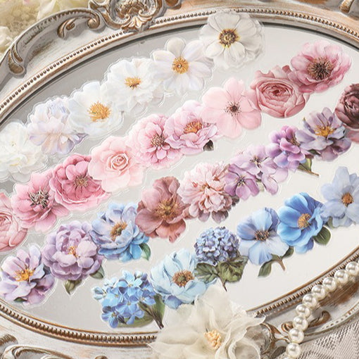 Rows of pink, white, purple and blue flower stickers on a mirror tray