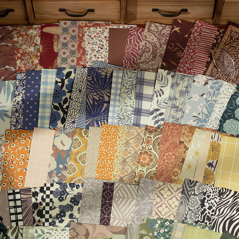Fanned stack of vintage-style scrapbooking paper sheets in warm floral, plaid, and gingham patterns
