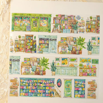 Watercolor PET tape artwork with cozy bookshop storefronts, stacked bookshelves, plants, and reading corners