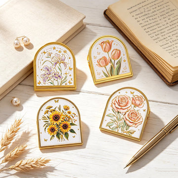 Four gold-trim enamel journal clips with embossed iris, tulip, sunflower, and rose designs